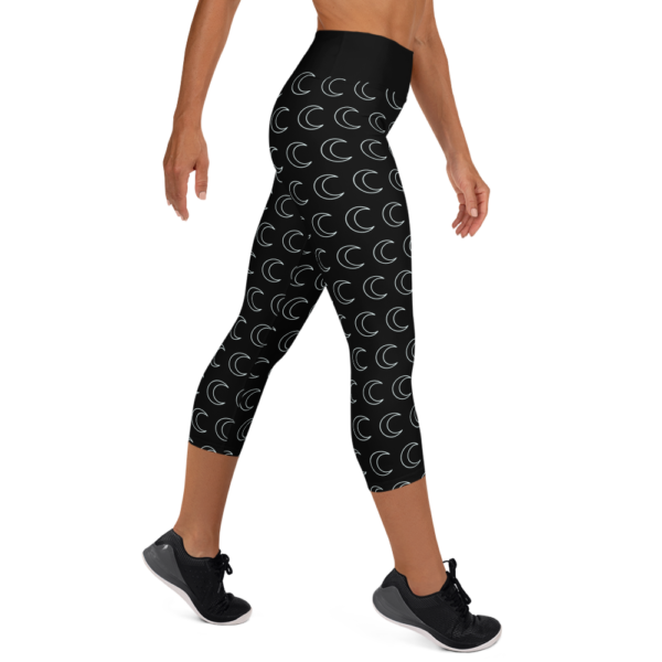 woman wearing black yoga capri leggings with white crescent moon pattern