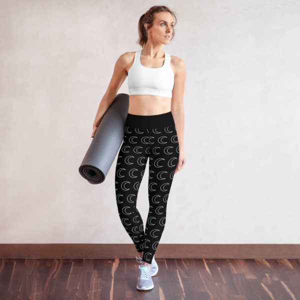 woman wearing black yoga leggings with white crescent moon pattern